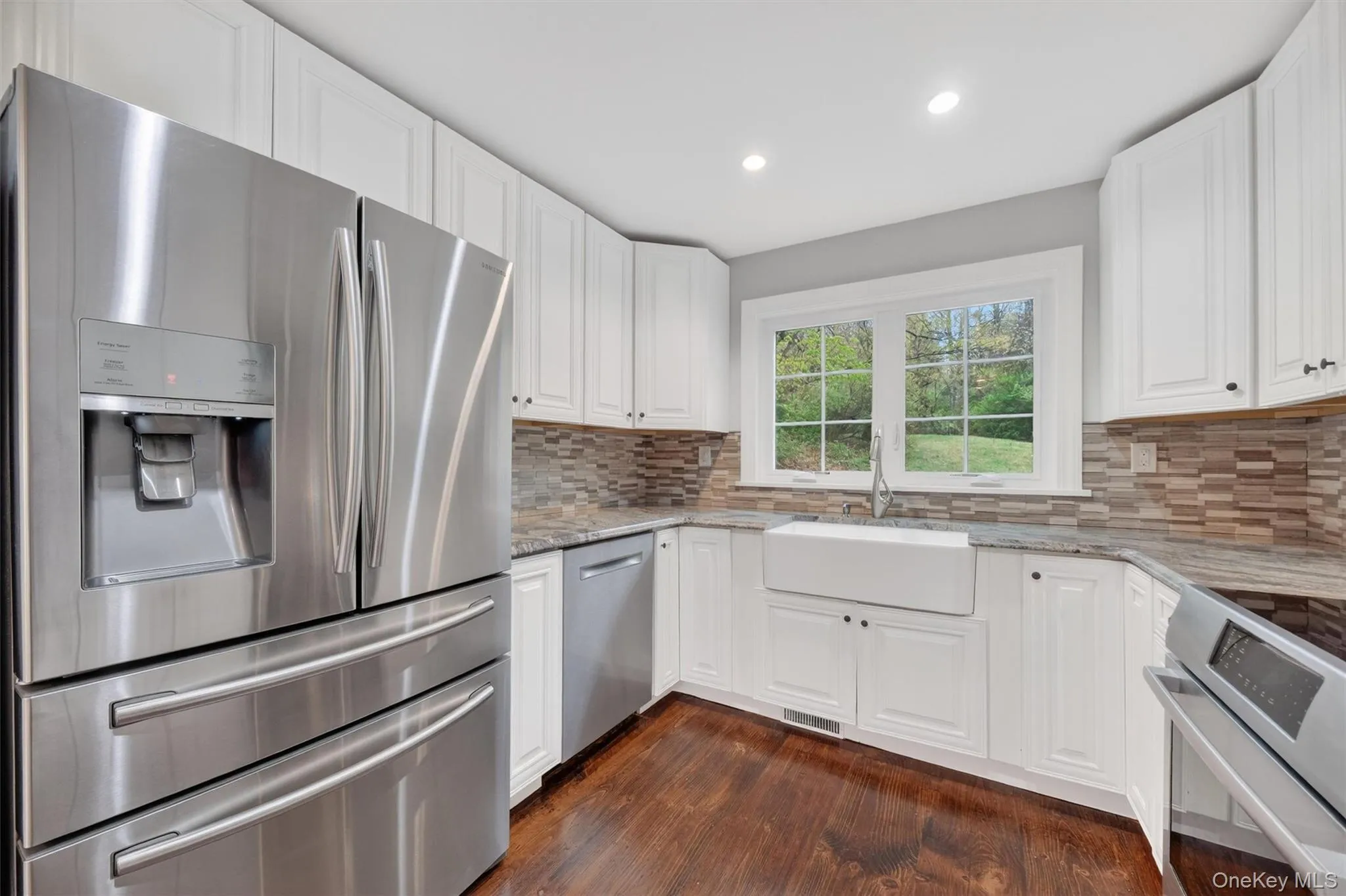 Renovated kitchen with granite countertops, tile backsplash, recessed lighting, & stainless steel appliances. Renovated kitchen with granite countertops, tile backsplash, recessed lighting, & stainless steel appliances.