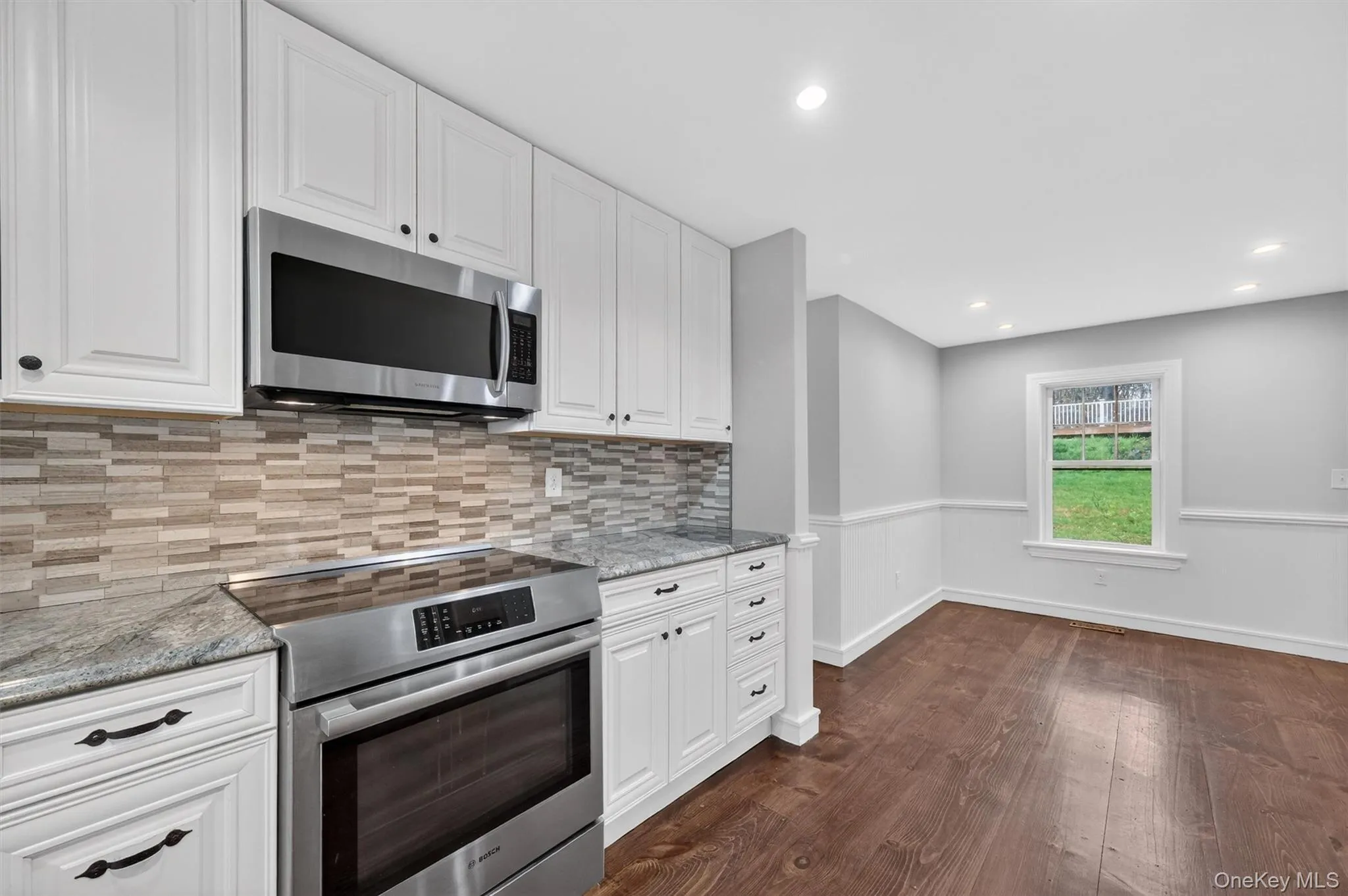Renovated kitchen with granite countertops, tile backsplash, recessed lighting, & stainless steel appliances. Renovated kitchen with granite countertops, tile backsplash, recessed lighting, & stainless steel appliances.