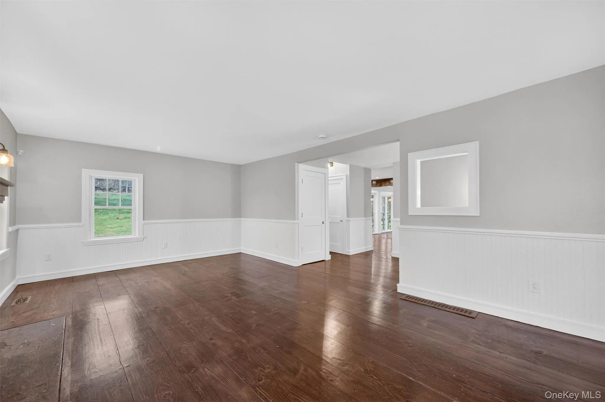Formal living room with decorative stone fireplace, hardwood floors, and beadboard wainscoting. Formal living room with decorative stone fireplace, hardwood floors, and beadboard wainscoting.
