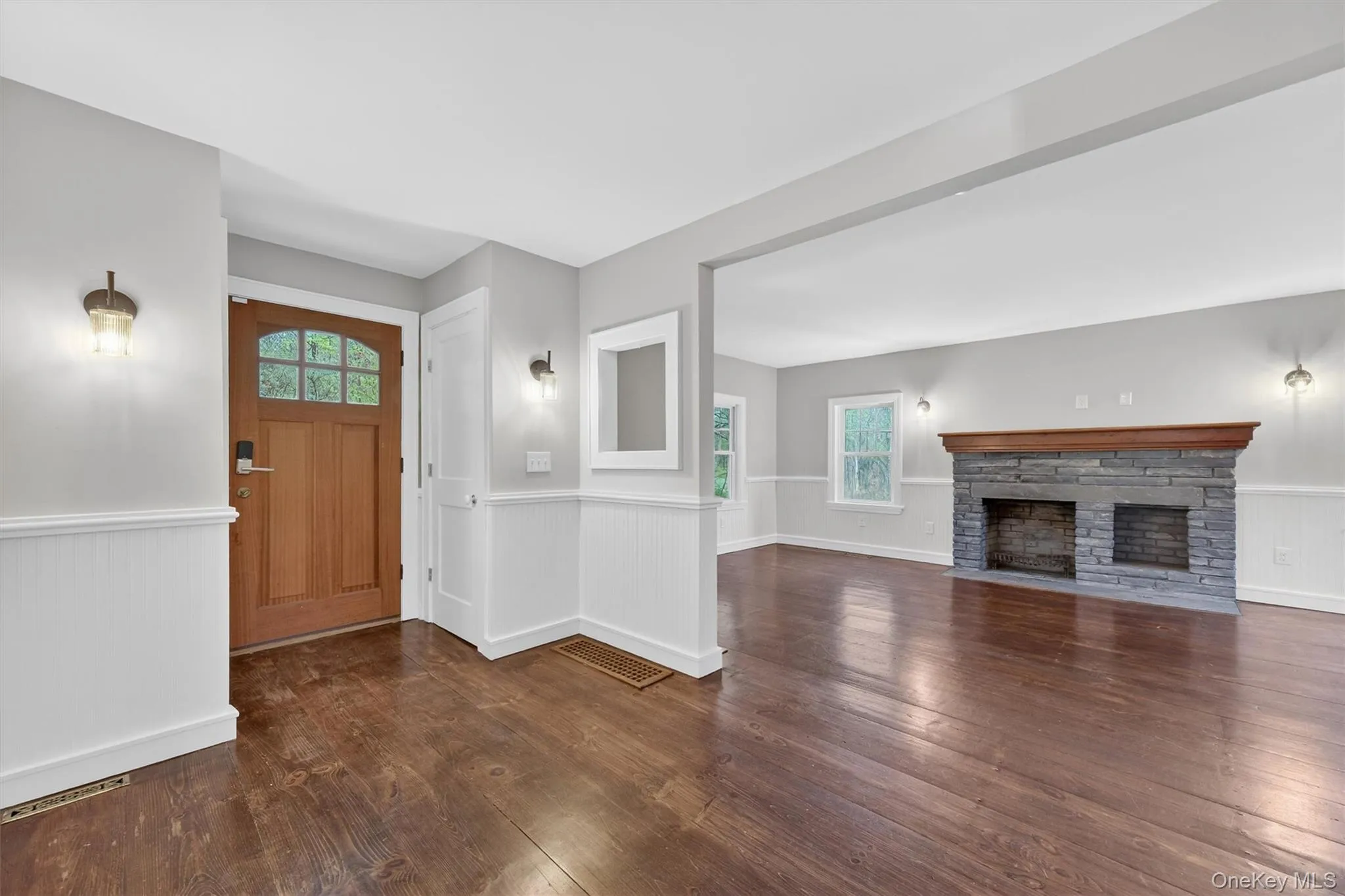 Formal living room with decorative stone fireplace, hardwood floors, and beadboard wainscoting. Formal living room with decorative stone fireplace, hardwood floors, and beadboard wainscoting.