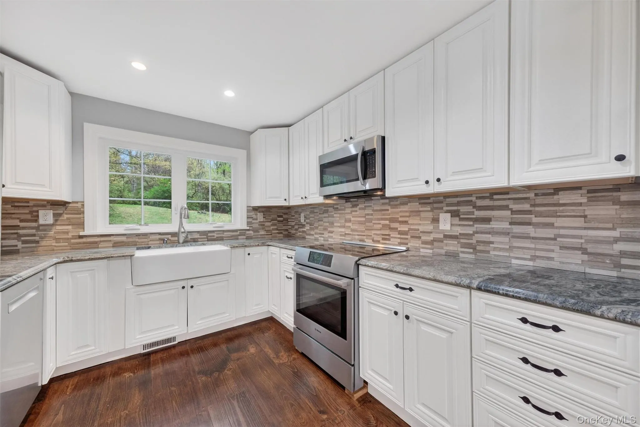 Renovated kitchen with granite countertops, tile backsplash, recessed lighting, & stainless steel appliances. Renovated kitchen with granite countertops, tile backsplash, recessed lighting, & stainless steel appliances.