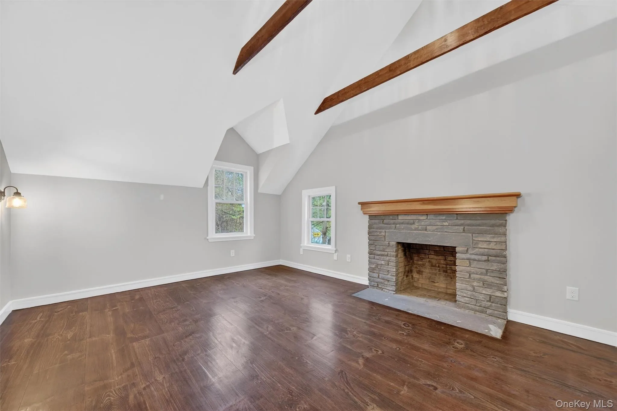 Primary bedroom with exposed beams, hardwood floors, decorative fireplace, and en-suite bathroom. Primary bedroom with exposed beams, hardwood floors, decorative fireplace, and en-suite bathroom.