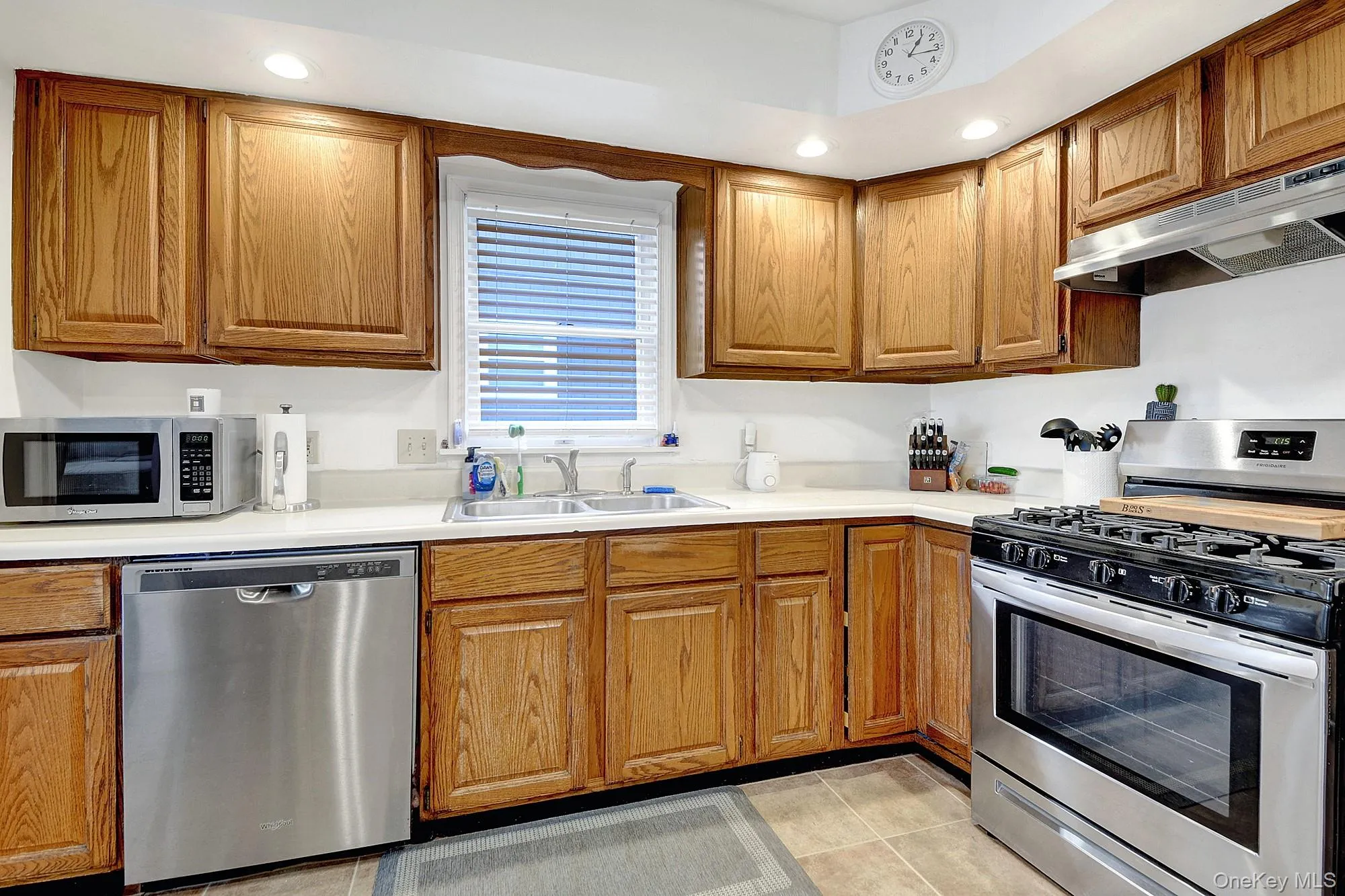 Large separate windowed galley kitchen with hardwood cabinets and stainless steel appliances Large separate windowed galley kitchen with hardwood cabinets and stainless steel appliances