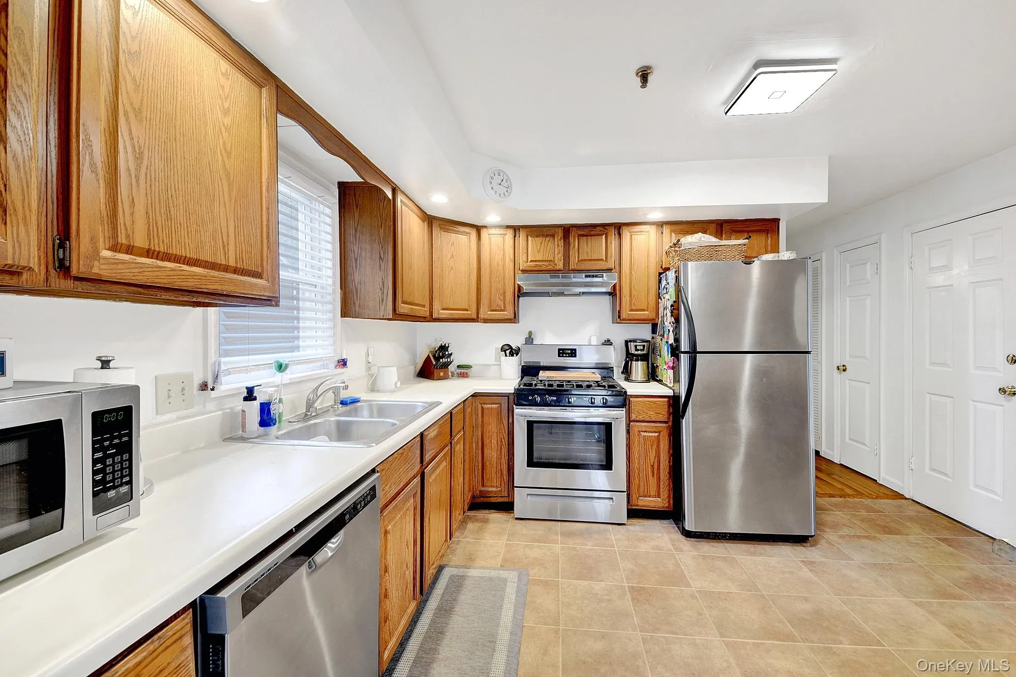 Large separate windowed galley kitchen with hardwood cabinets and stainless steel appliances Large separate windowed galley kitchen with hardwood cabinets and stainless steel appliances