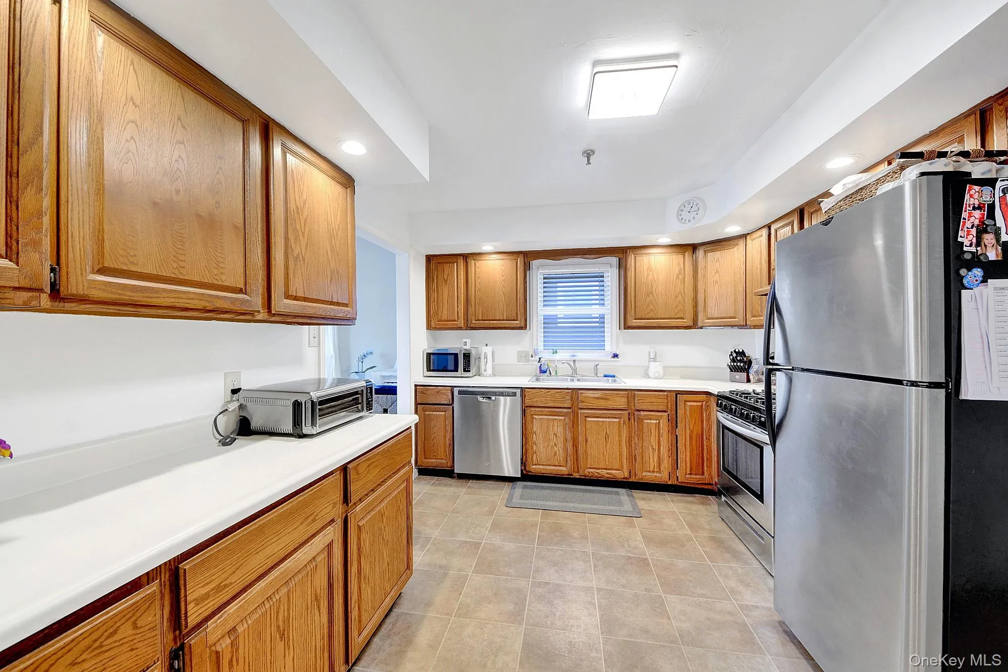 Large separate windowed galley kitchen with hardwood cabinets and stainless steel appliances Large separate windowed galley kitchen with hardwood cabinets and stainless steel appliances