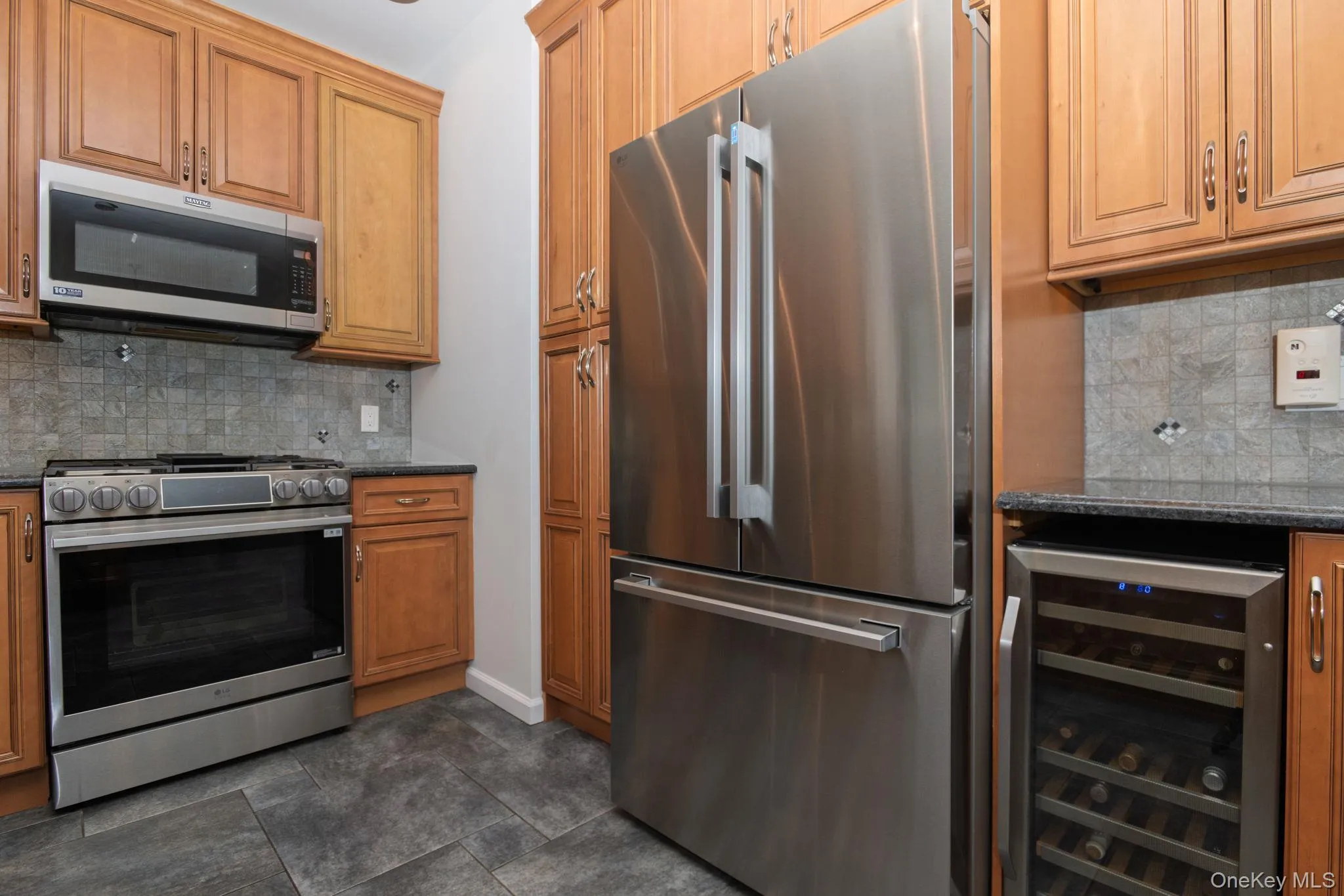 Modern kitchen appliances featuring a stainless steel refrigerator, gas range, and built-in microwave Modern kitchen appliances featuring a stainless steel refrigerator, gas range, and built-in microwave