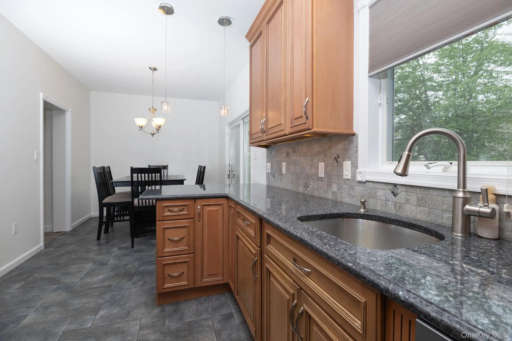 Kitchen featuring a stainless steel undermount sink, granite countertops, and a tiled backsplash Kitchen featuring a stainless steel undermount sink, granite countertops, and a tiled backsplash