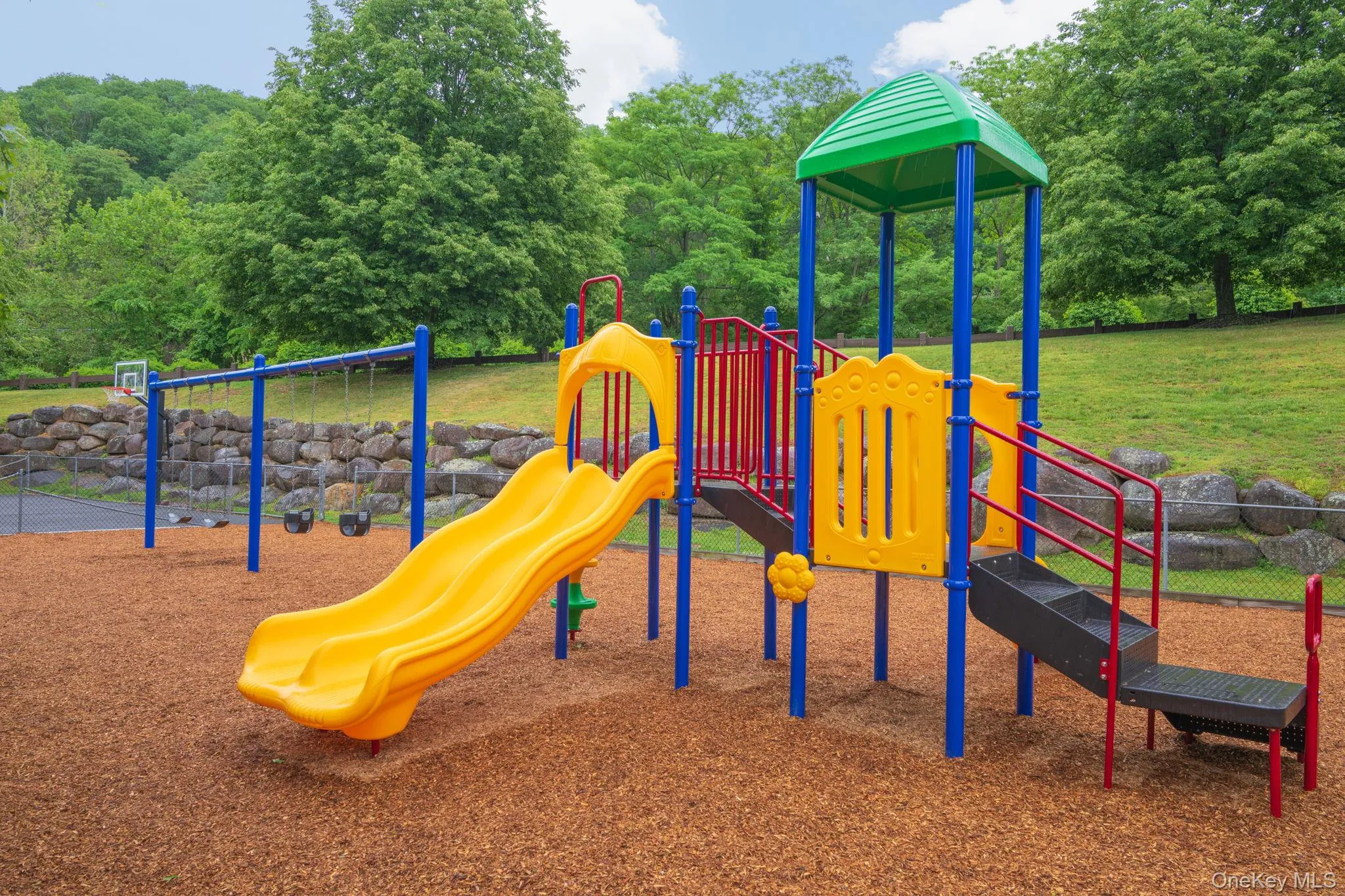 Outdoor play structure featuring a yellow slide, climbing steps, and a green canopy Outdoor play structure featuring a yellow slide, climbing steps, and a green canopy