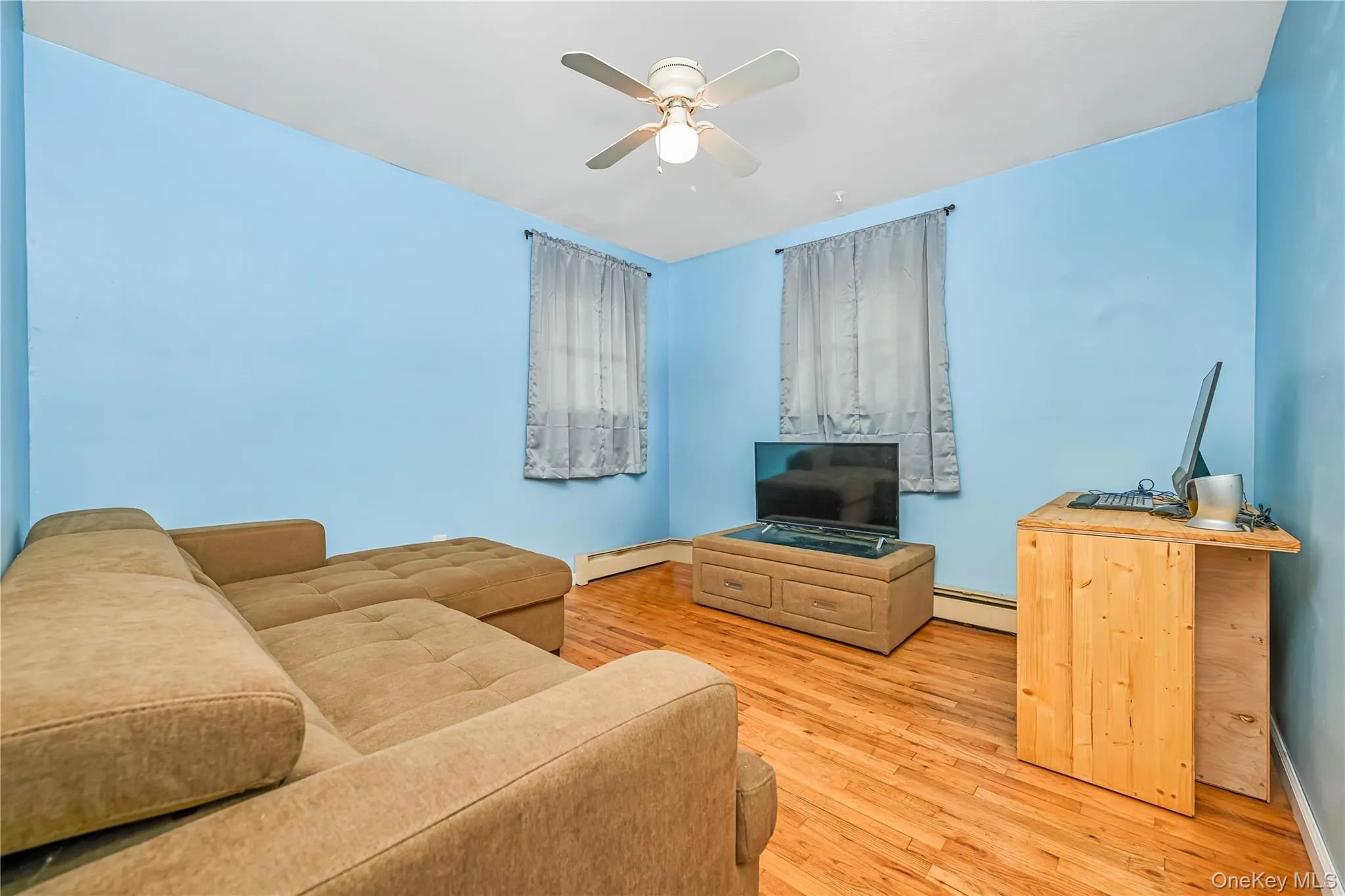 Room featuring wood-finish flooring and a ceiling fan Room featuring wood-finish flooring and a ceiling fan