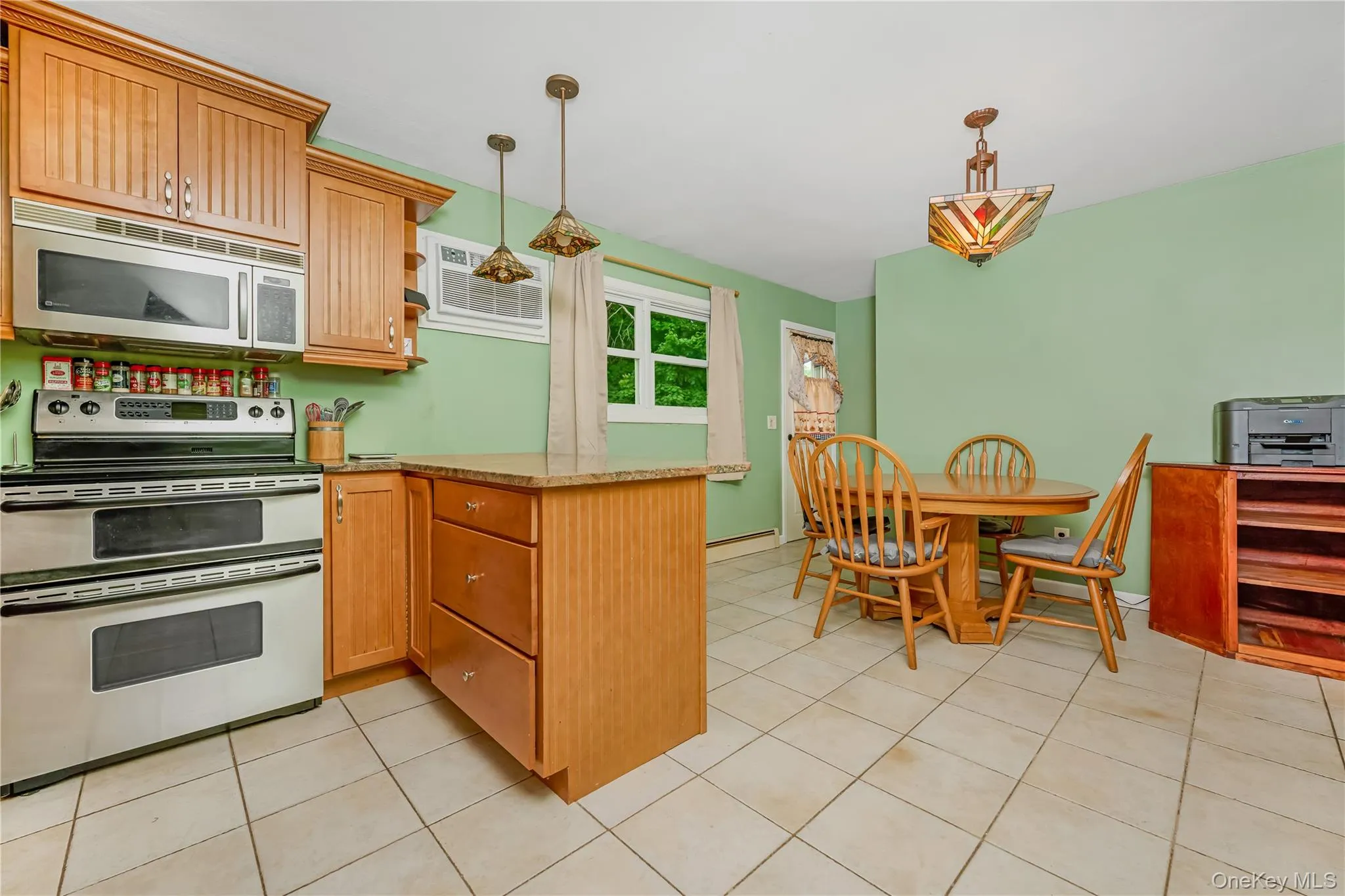 Kitchen featuring stainless steel appliances, wood cabinetry, stone countertops, and tile flooring Kitchen featuring stainless steel appliances, wood cabinetry, stone countertops, and tile flooring