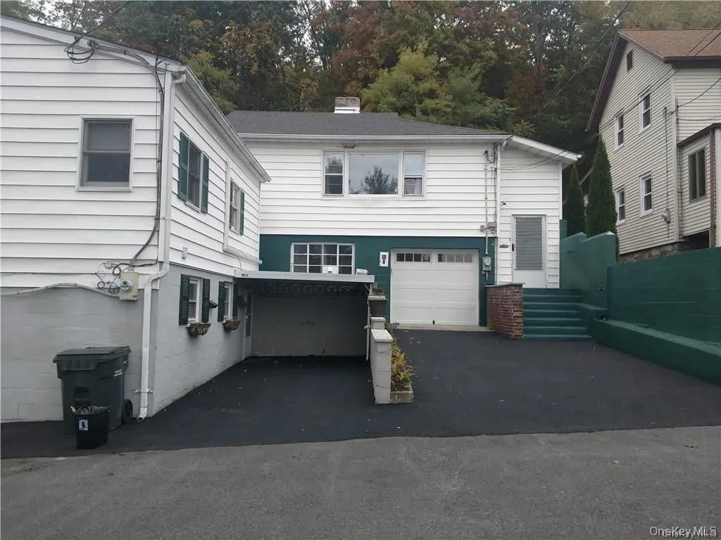View of front of house with driveway, a chimney, and a garage View of front of house with driveway, a chimney, and a garage