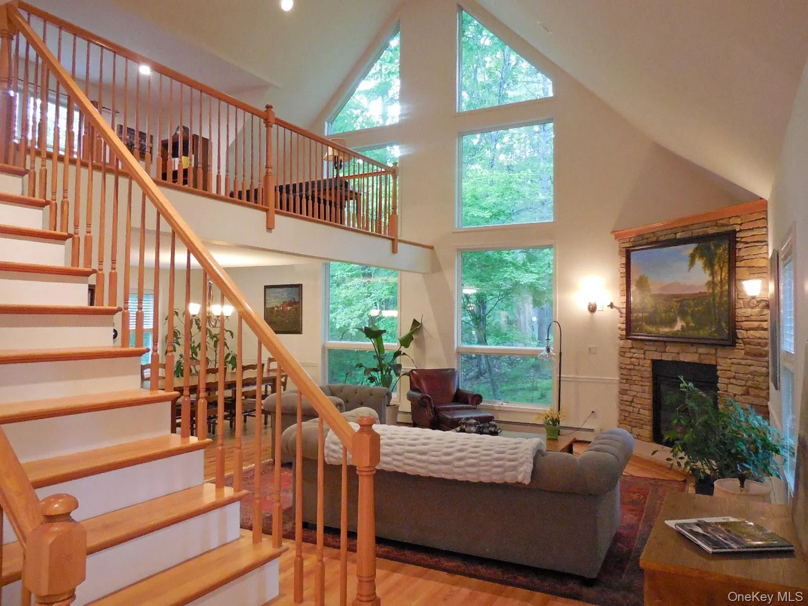 Great room with floor to ceiling windows, stone fireplace, inlaid hdwd floors, & open loft above Great room with floor to ceiling windows, stone fireplace, inlaid hdwd floors, & open loft above