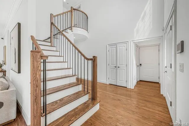 Grand entry foyer featuring a two-story ceiling and wood-finish flooring Grand entry foyer featuring a two-story ceiling and wood-finish flooring