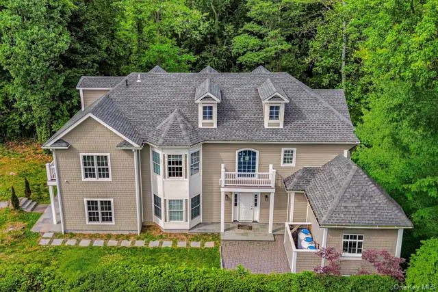 Contemporary residence featuring a multi-gabled roofline and dormer windows, bay window, exterior balcony, and a paved driveway Contemporary residence featuring a multi-gabled roofline and dormer windows, bay window, exterior balcony, and a paved driveway