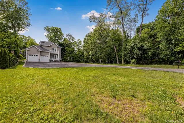 Contemporary residence with a light gray exterior and white trim, featuring a two-car garage Contemporary residence with a light gray exterior and white trim, featuring a two-car garage