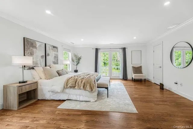 Expansive room with rich wood-finish flooring and crown molding Expansive room with rich wood-finish flooring and crown molding