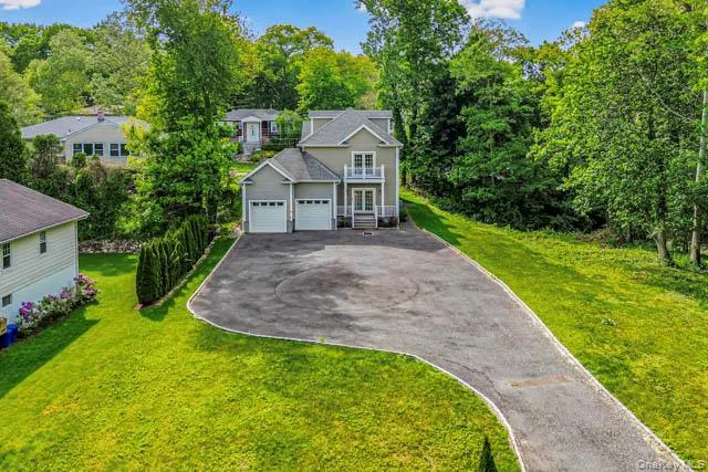Two-story residence featuring a neutral exterior, dual garage doors, and a second-level balcony Two-story residence featuring a neutral exterior, dual garage doors, and a second-level balcony