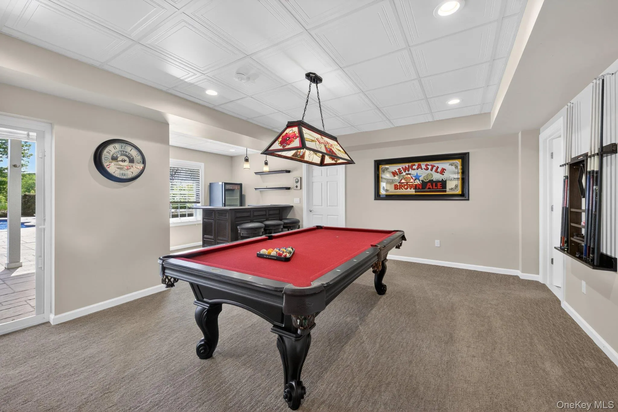 Recreation room featuring a full-size billiards table, wet bar with built-in cabinetry, recessed lighting, and direct patio access Recreation room featuring a full-size billiards table, wet bar with built-in cabinetry, recessed lighting, and direct patio access