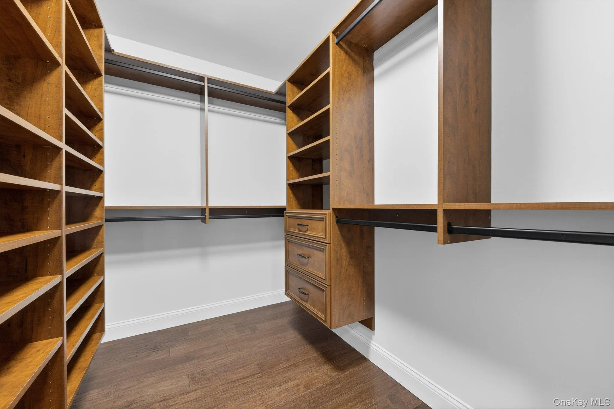 Custom closet system featuring extensive shelving, built-in drawers, and multiple hanging rods Custom closet system featuring extensive shelving, built-in drawers, and multiple hanging rods