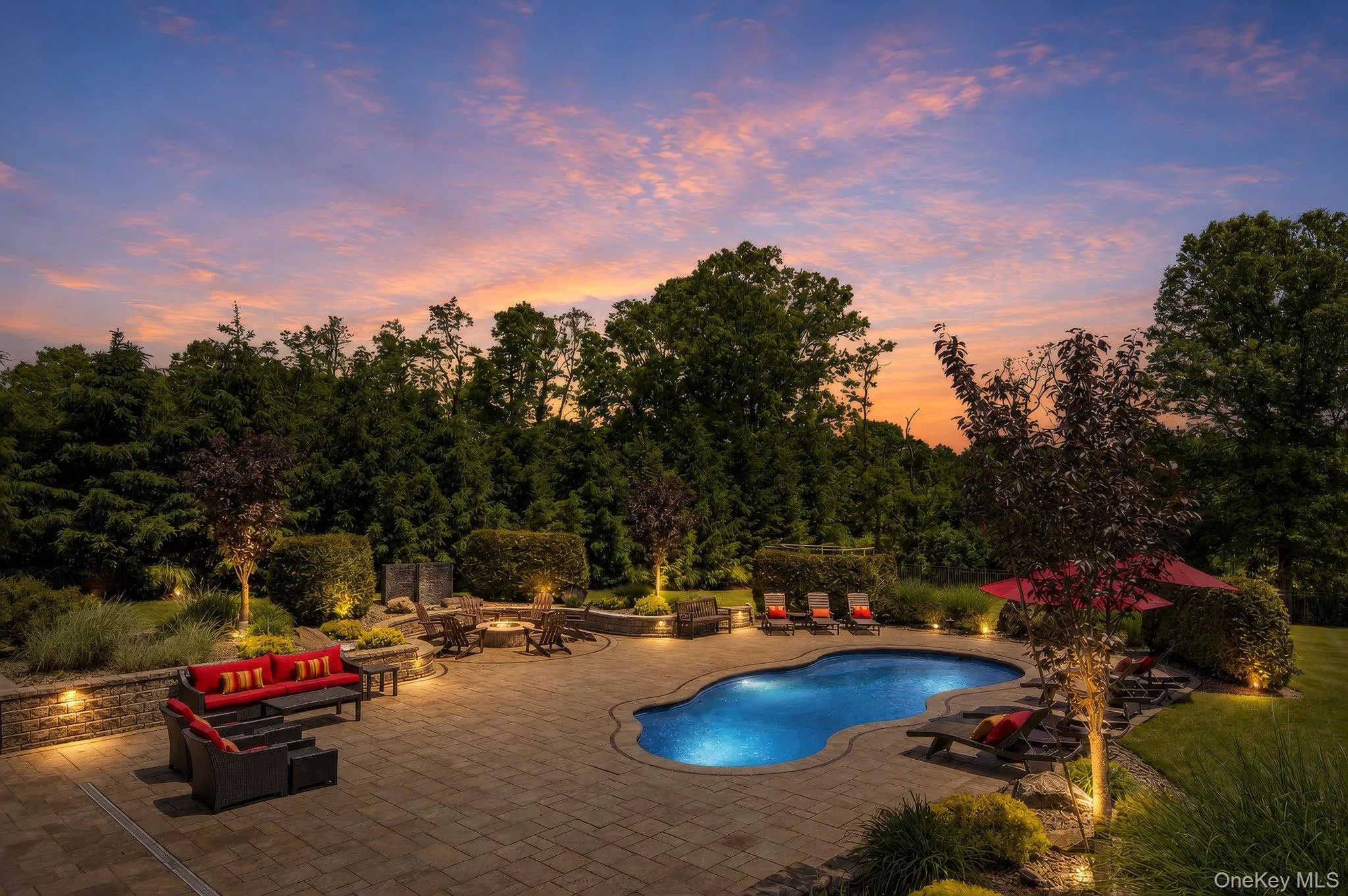 Freeform swimming pool with integrated lighting on a paver patio Freeform swimming pool with integrated lighting on a paver patio
