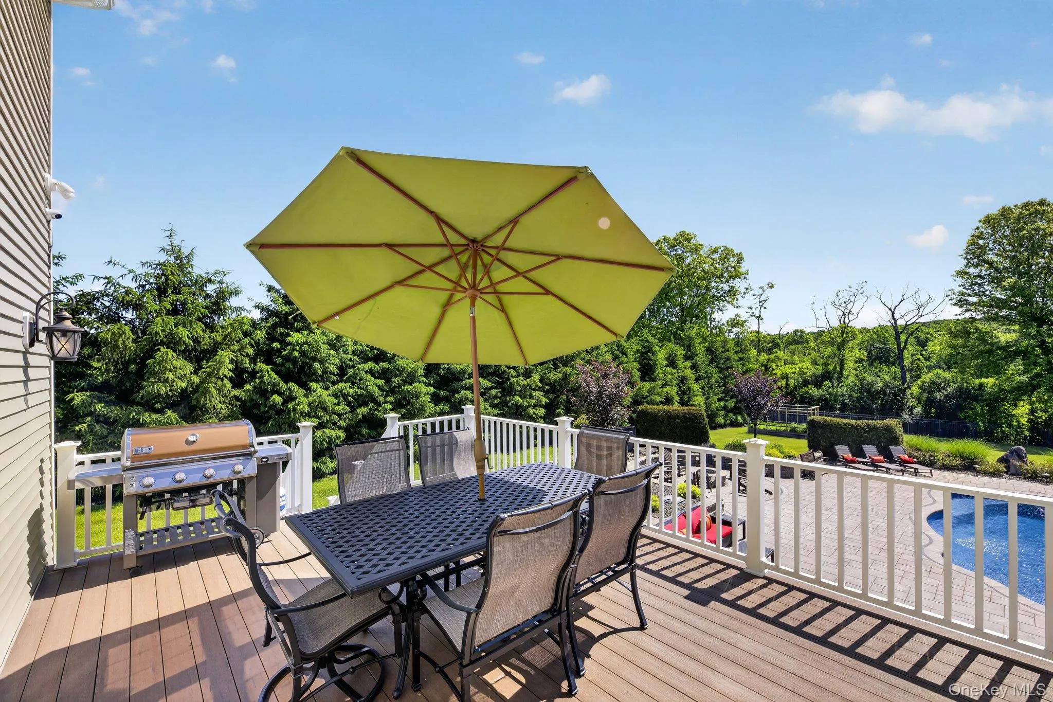 Spacious outdoor deck with wood-finish flooring and white railings Spacious outdoor deck with wood-finish flooring and white railings