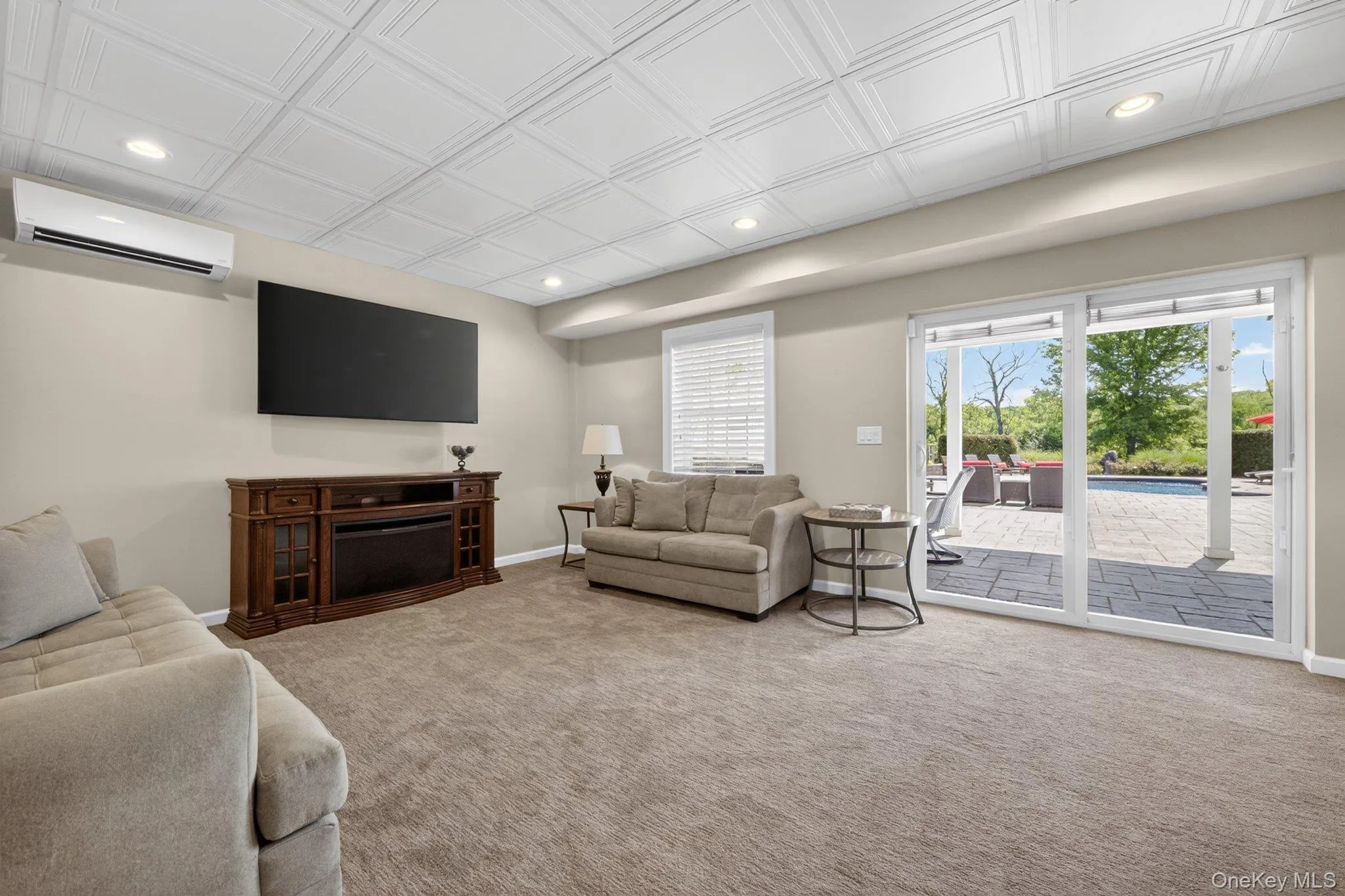Spacious interior room featuring plush carpeting and a decorative ceiling with recessed lighting Spacious interior room featuring plush carpeting and a decorative ceiling with recessed lighting