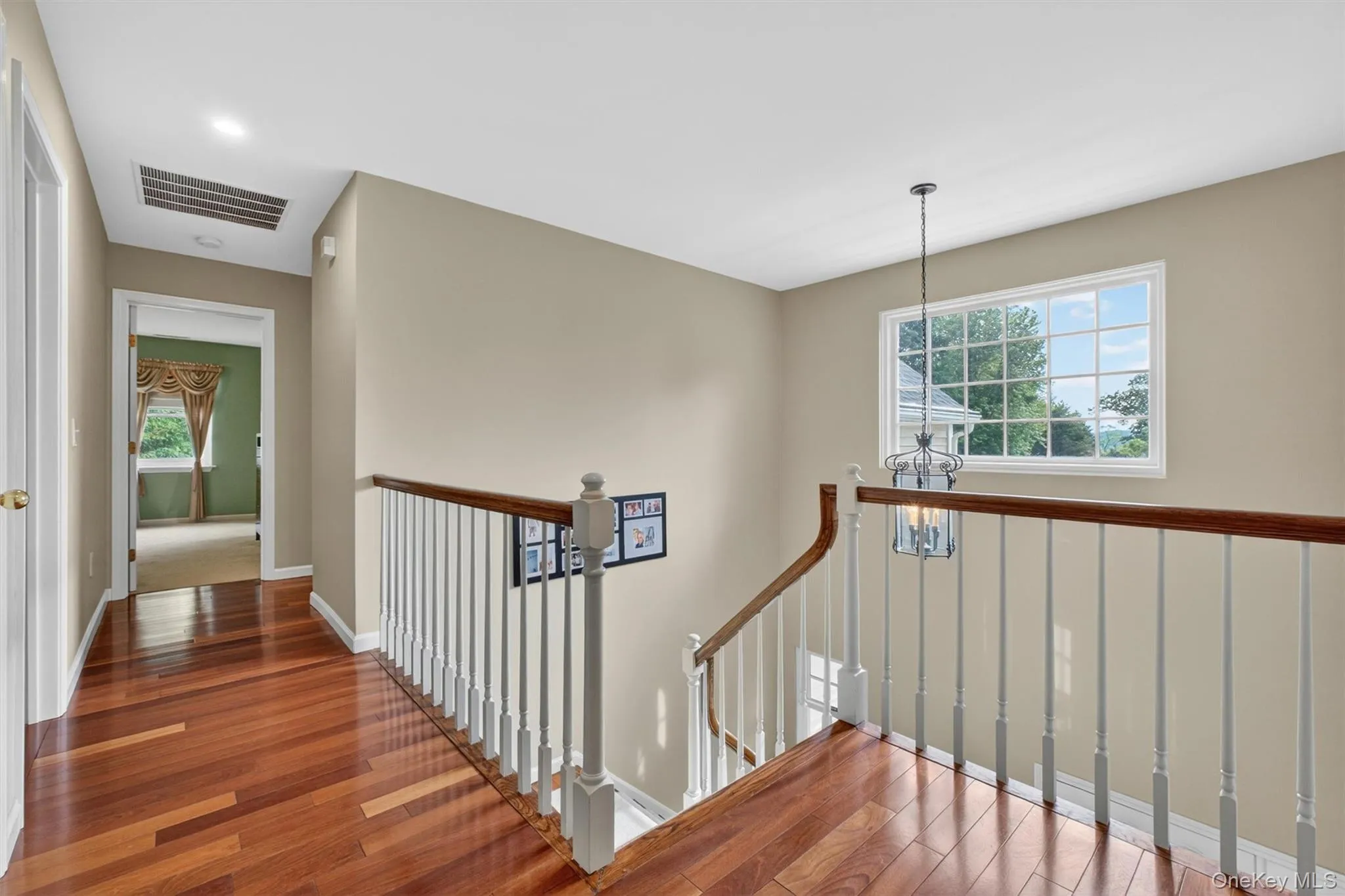 Second-floor landing with hardwood floors and abundant natural light. Second-floor landing with hardwood floors and abundant natural light.