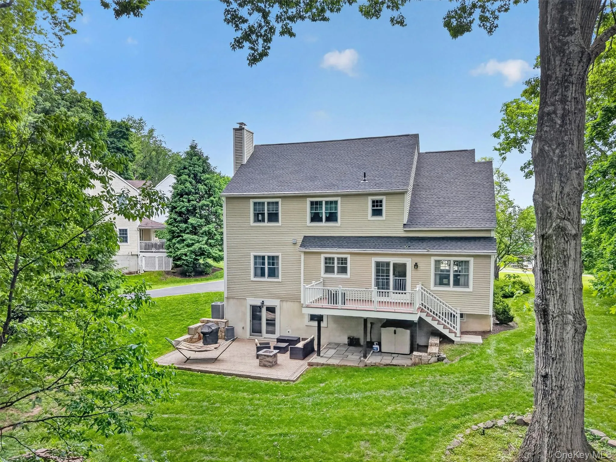 Rear elevation showcasing the expansive deck and lower patio retreat. Rear elevation showcasing the expansive deck and lower patio retreat.