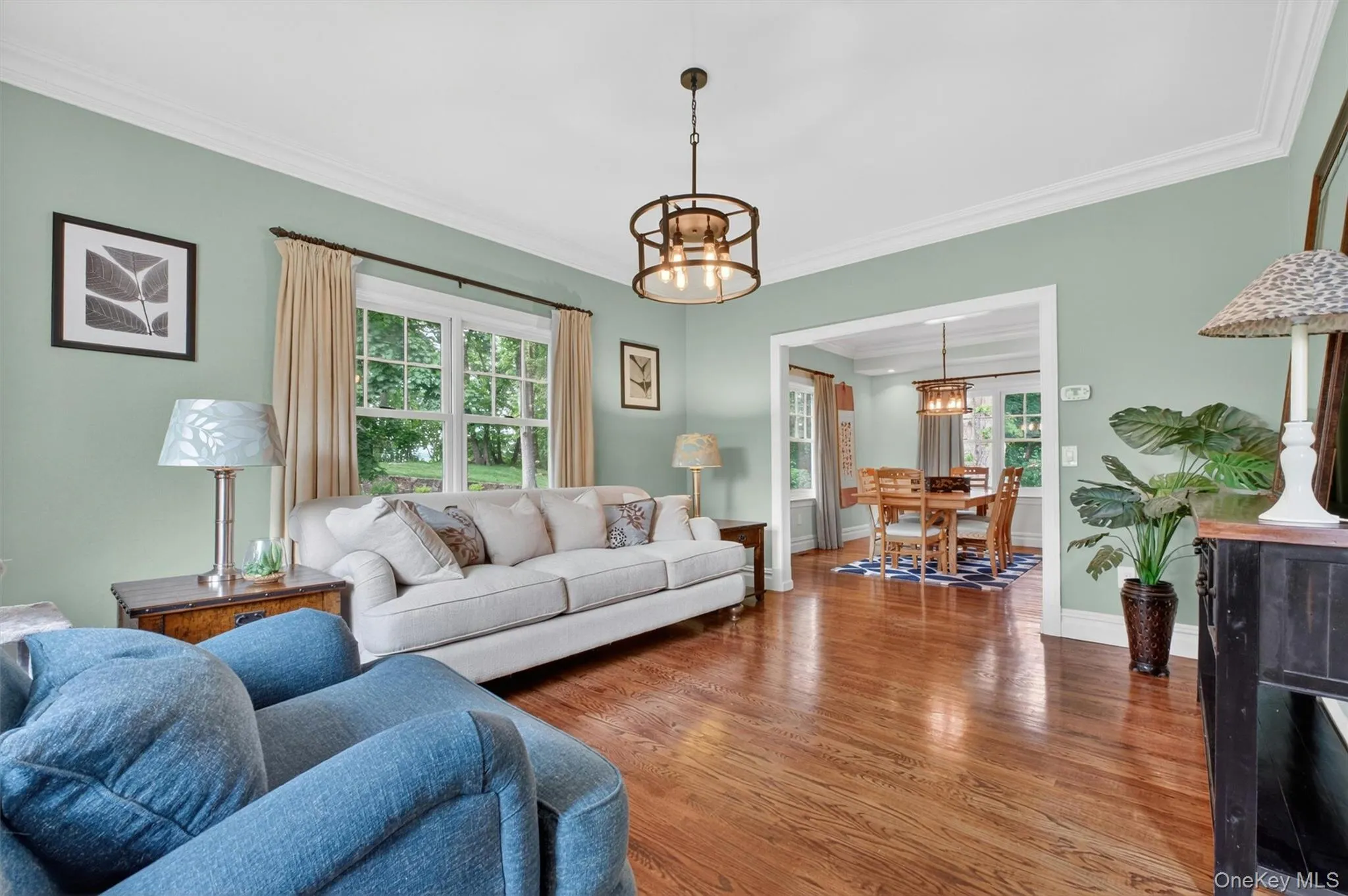 Spacious formal living room with hardwood floors and oversized windows. Spacious formal living room with hardwood floors and oversized windows.