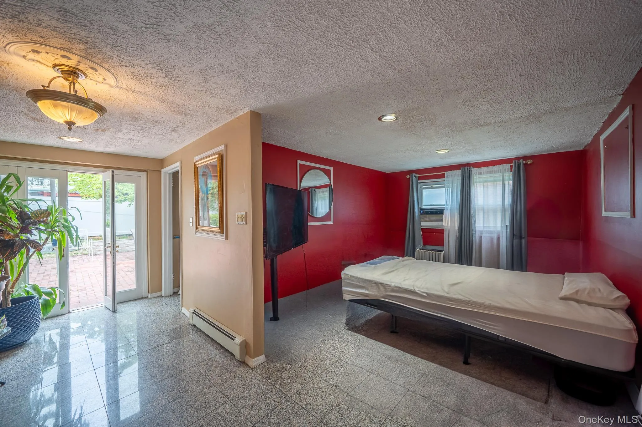 Bedroom with baseboard heating, access to exterior, recessed lighting, and a textured ceiling Bedroom with baseboard heating, access to exterior, recessed lighting, and a textured ceiling