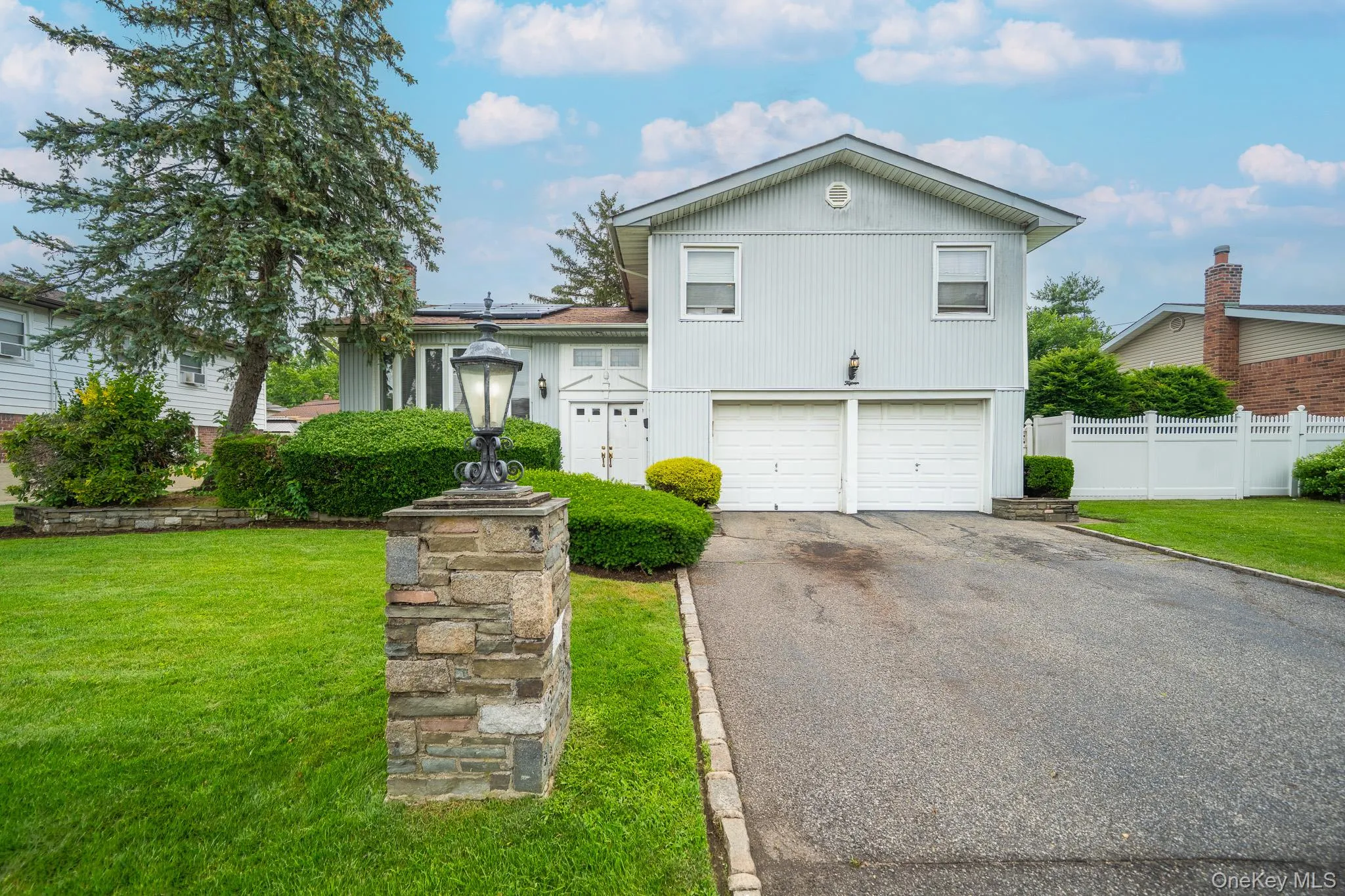 Split level home with asphalt driveway and an attached garage Split level home with asphalt driveway and an attached garage