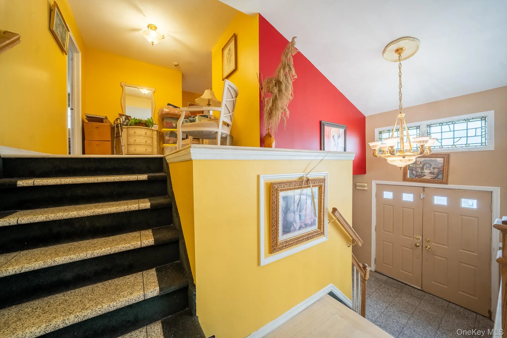 Foyer entrance with a chandelier, vaulted ceiling, stairs, and granite tiled floors Foyer entrance with a chandelier, vaulted ceiling, stairs, and granite tiled floors