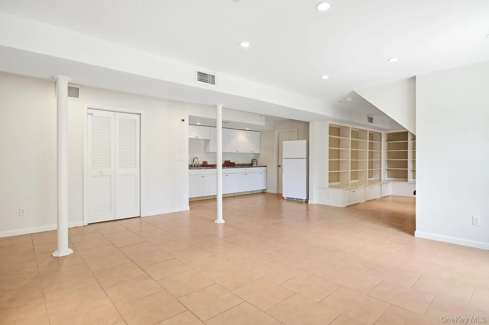 Another split level below, the enormous recreation room, remodeled in 2015, features a second fireplace, summer kitchen, wet bar, and direct access to the rear patio, creating the perfect setting for entertaining, extended guests, or flexible living needs. Another split level below, the enormous recreation room, remodeled in 2015, features a second fireplace, summer kitchen, wet bar, and direct access to the rear patio, creating the perfect setting for entertaining, extended guests, or flexible living needs.
