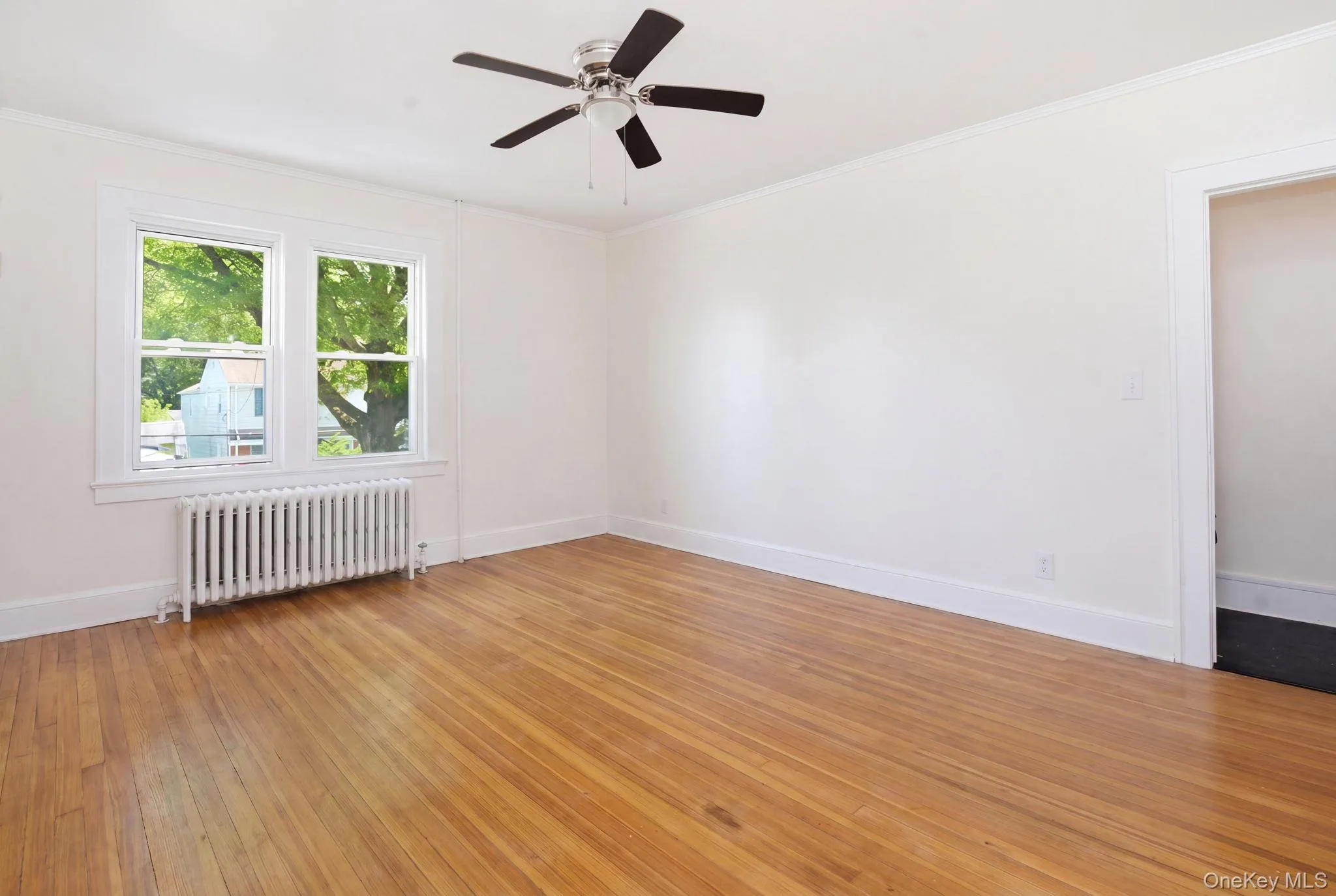 Spacious bedrooms featuring hard wood flooring, white walls, and a ceiling fan Spacious bedrooms featuring hard wood flooring, white walls, and a ceiling fan