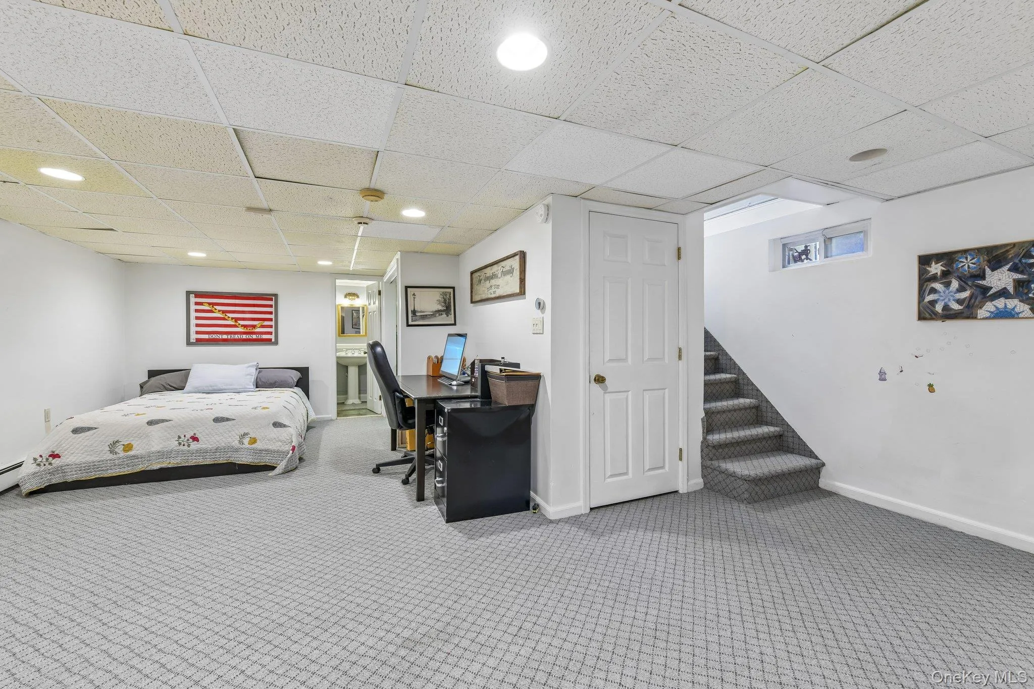 Finished lower level featuring patterned carpeting, recessed lighting, and a drop ceiling Finished lower level featuring patterned carpeting, recessed lighting, and a drop ceiling