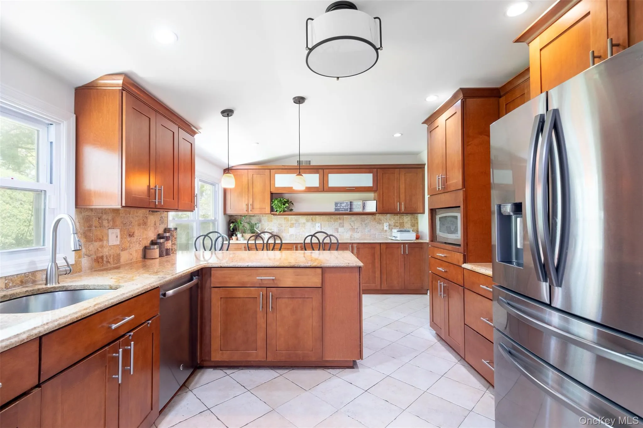 Kitchen with appliances with stainless steel finishes, a sink, open shelves, brown cabinets, and a peninsula Kitchen with appliances with stainless steel finishes, a sink, open shelves, brown cabinets, and a peninsula