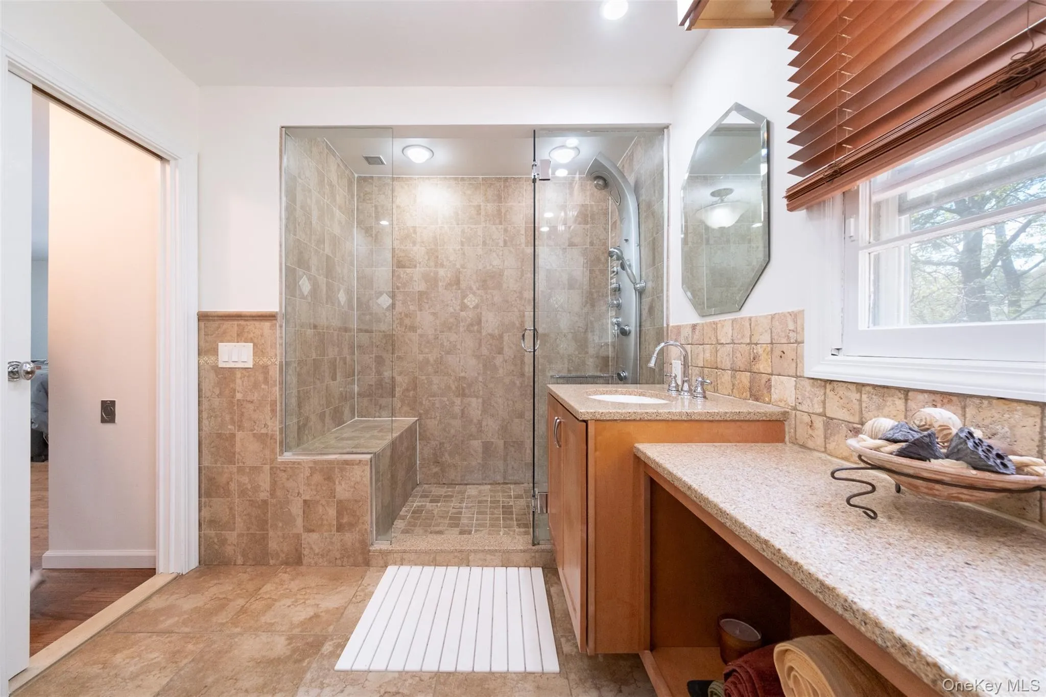 Full bathroom with a shower stall, vanity, and tile walls Full bathroom with a shower stall, vanity, and tile walls