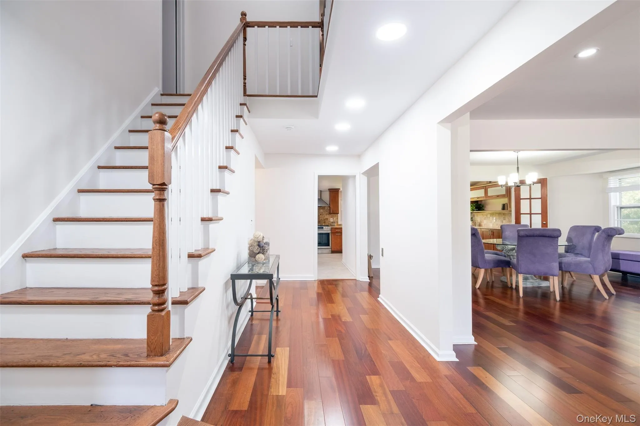 Stairway with a chandelier, hardwood / wood-style flooring, recessed lighting, and baseboards Stairway with a chandelier, hardwood / wood-style flooring, recessed lighting, and baseboards