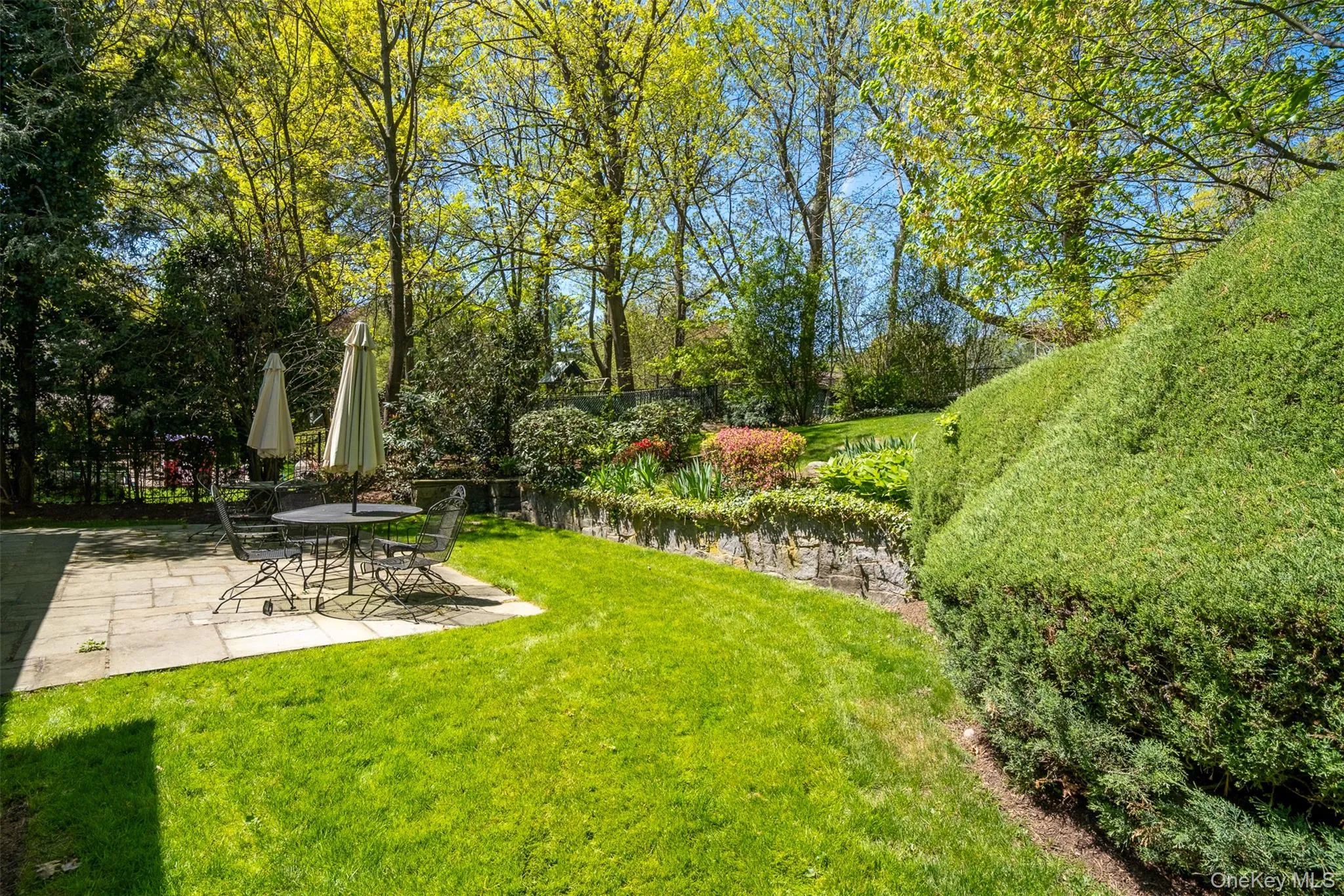 View of green lawn with a patio View of green lawn with a patio