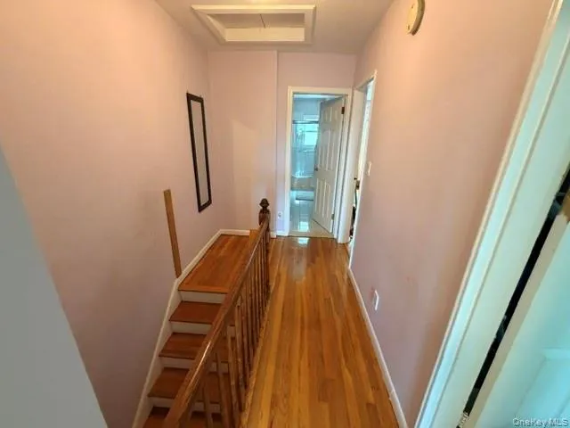 Hardwood flooring extends throughout this upper-level hallway, complemented by a light-colored wall finish Hardwood flooring extends throughout this upper-level hallway, complemented by a light-colored wall finish