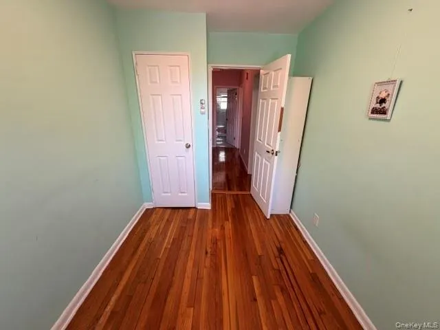 Hardwood flooring throughout featuring light green wall paint and white trim molding Hardwood flooring throughout featuring light green wall paint and white trim molding