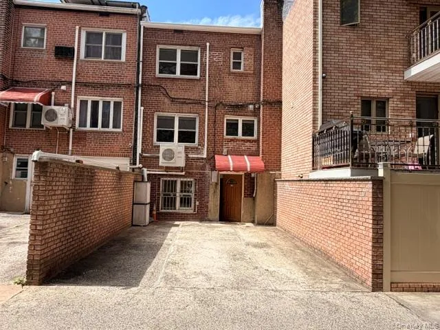 Paved concrete driveway with brick-faced retaining walls providing access to a multi-story brick building Paved concrete driveway with brick-faced retaining walls providing access to a multi-story brick building