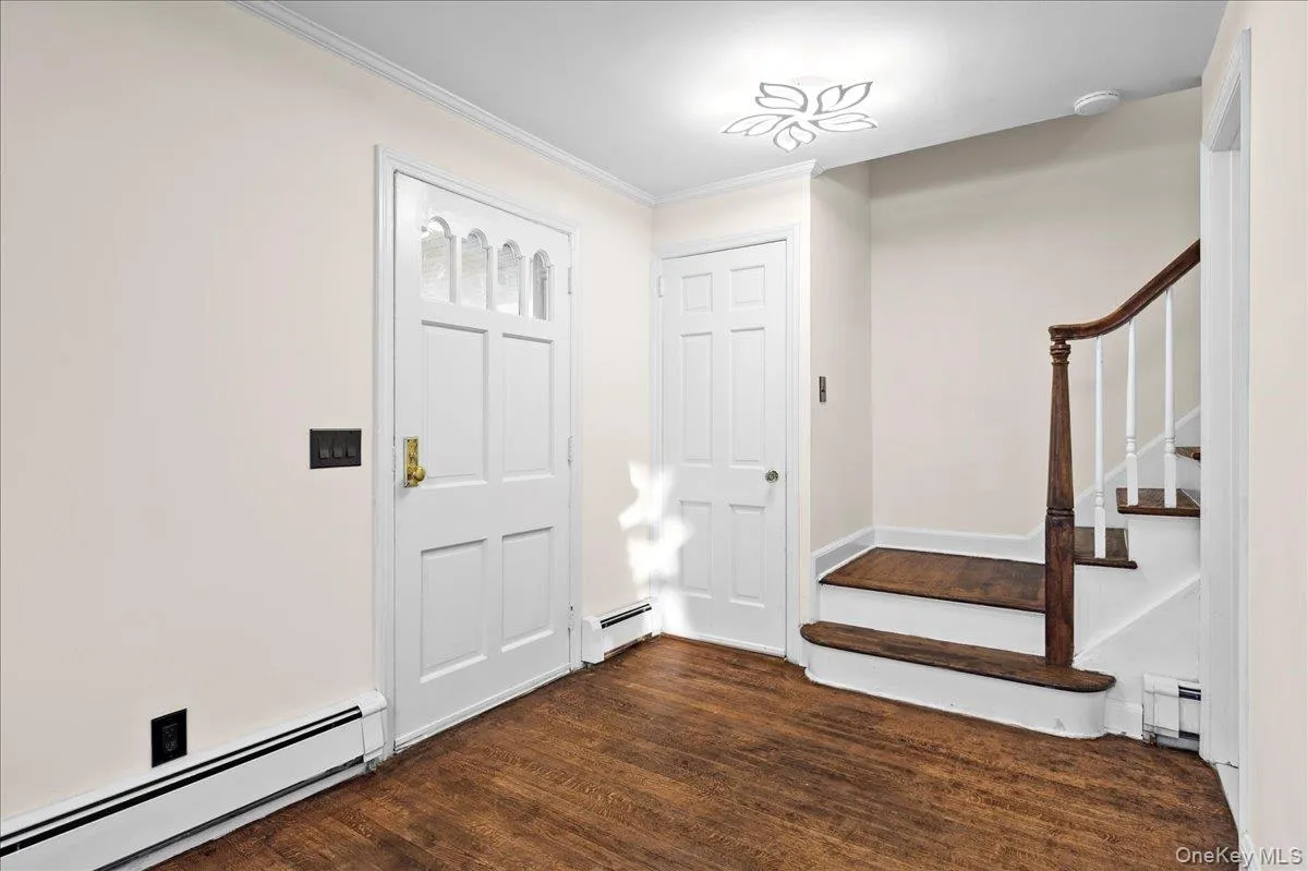 Entryway featuring wood-finish flooring and a decorative ceiling light fixture Entryway featuring wood-finish flooring and a decorative ceiling light fixture