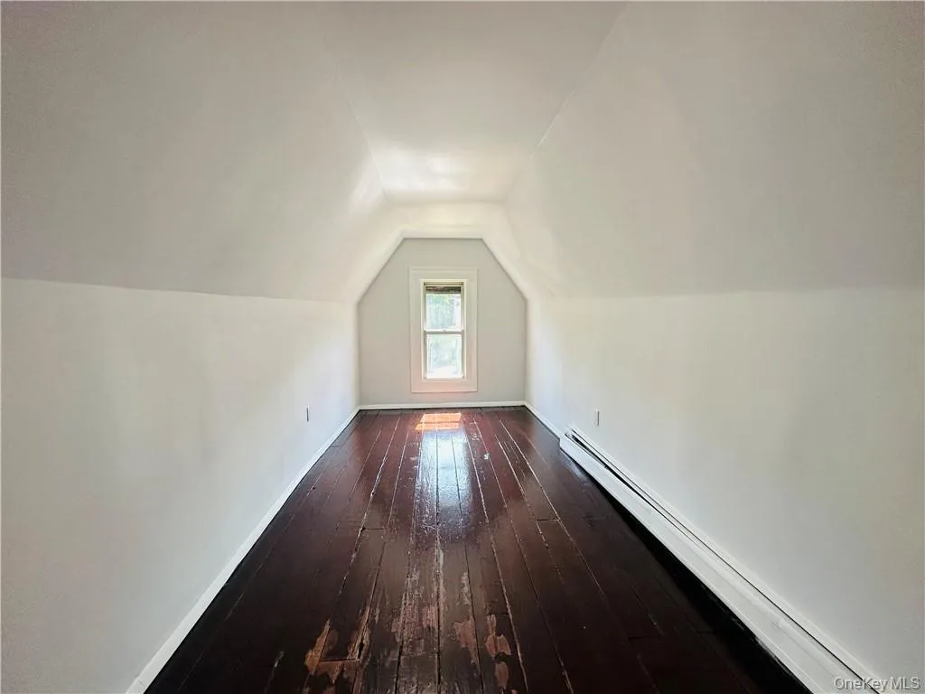 Additional living space with vaulted ceiling, and wood-type flooring Additional living space with vaulted ceiling, and wood-type flooring
