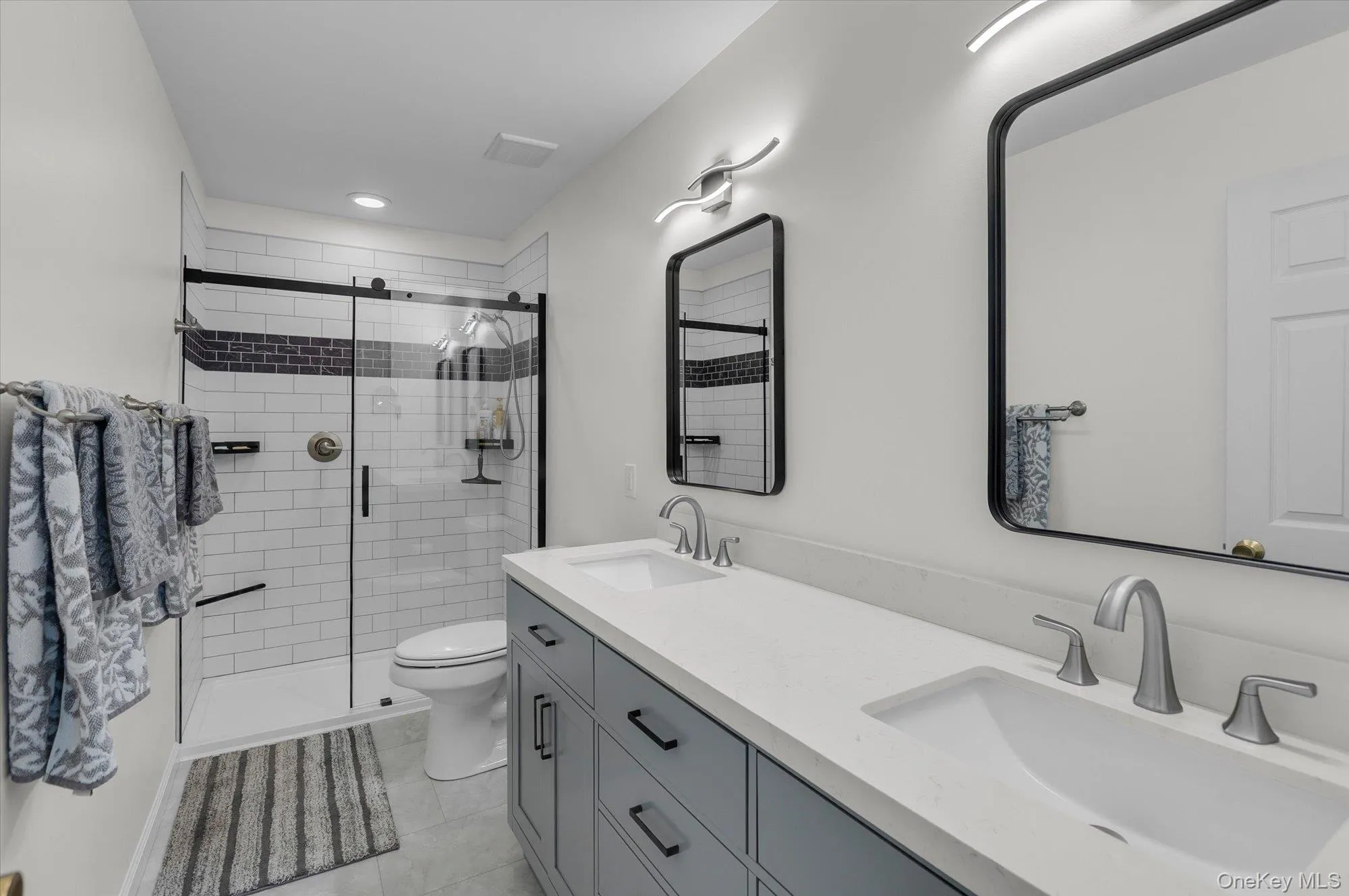 Updated and Modern. Double Sink Vanity. Step in shower. Ample cabinets. Decorative light fixtures. Updated and Modern. Double Sink Vanity. Step in shower. Ample cabinets. Decorative light fixtures.