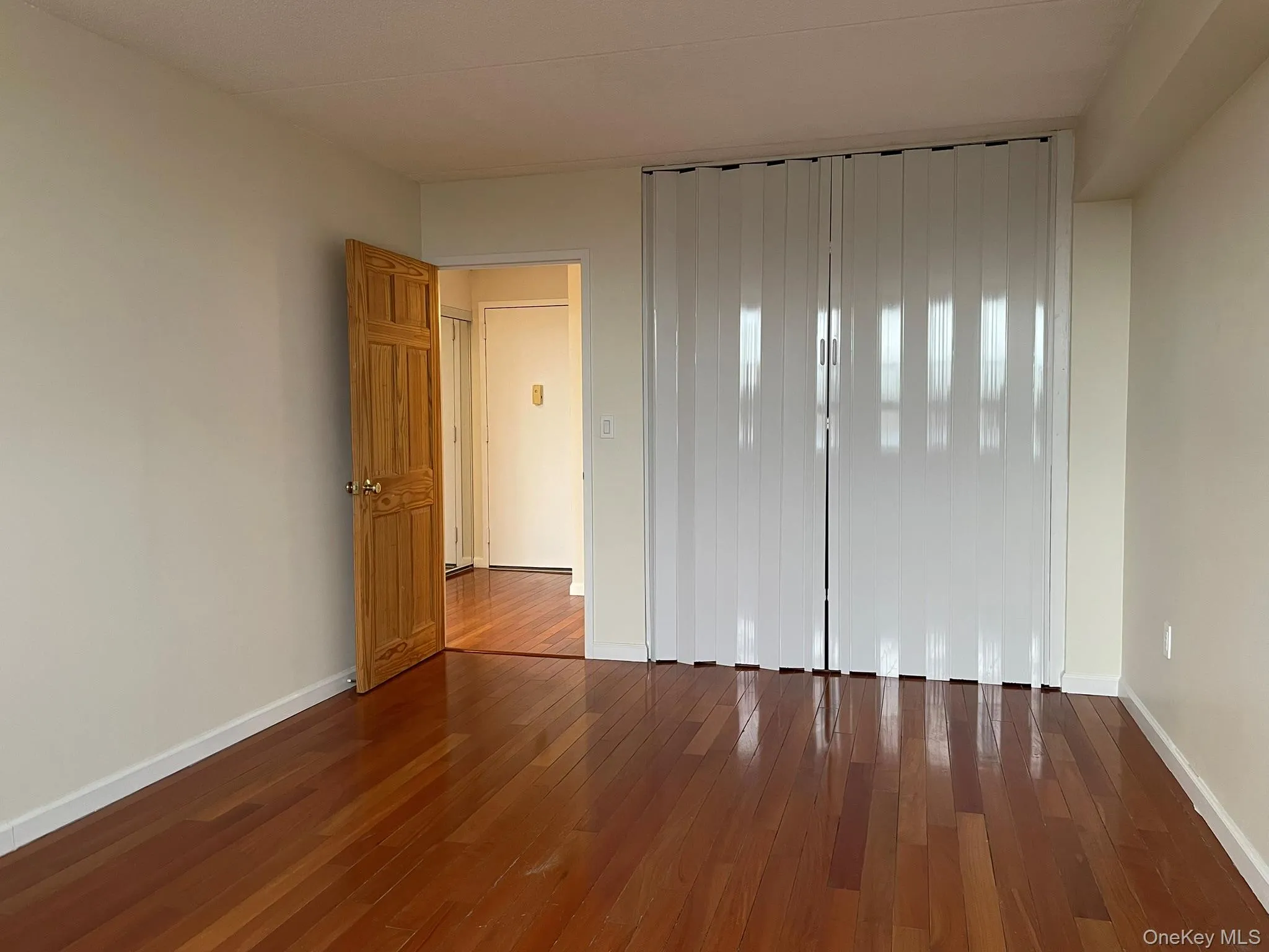 Empty room featuring baseboards and dark wood-style floors Empty room featuring baseboards and dark wood-style floors