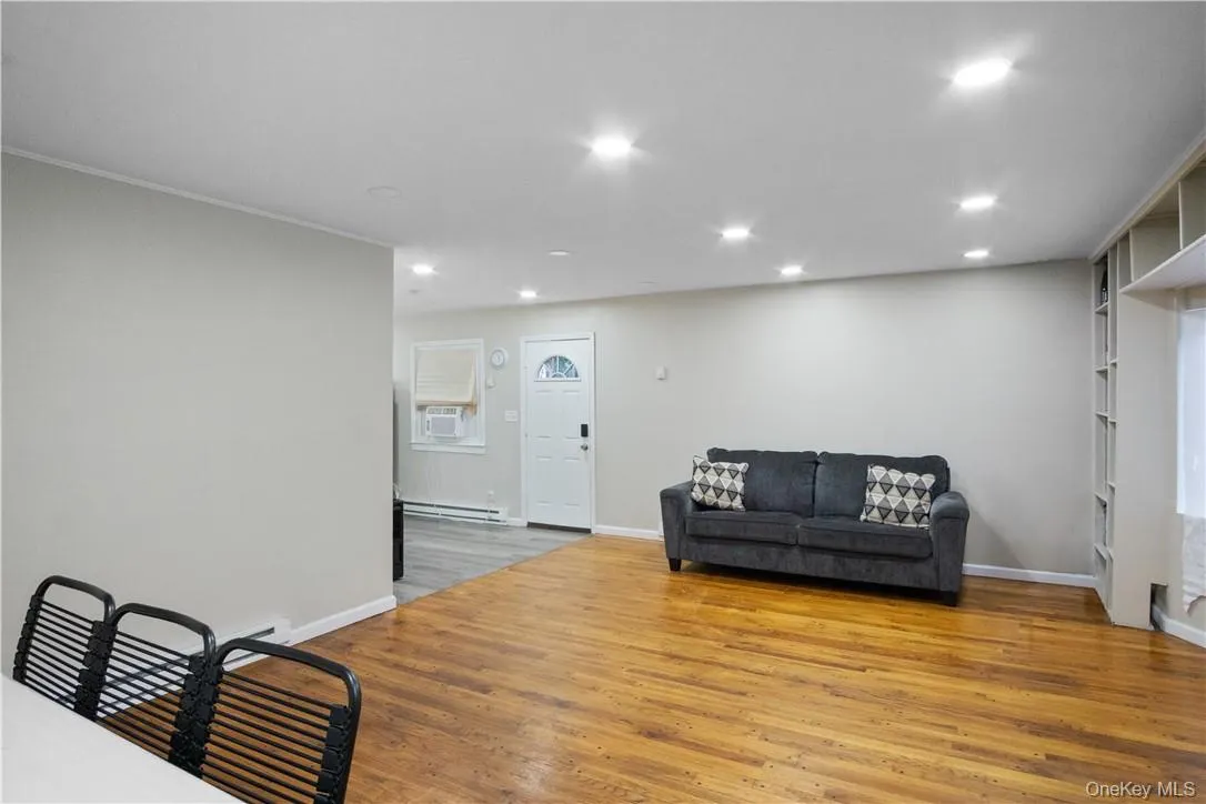 Living room with baseboard heating and light hardwood / wood-style floors Living room with baseboard heating and light hardwood / wood-style floors