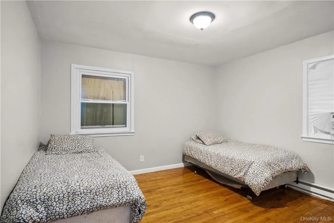 Bedroom with a baseboard heating unit and hardwood / wood-style floors Bedroom with a baseboard heating unit and hardwood / wood-style floors