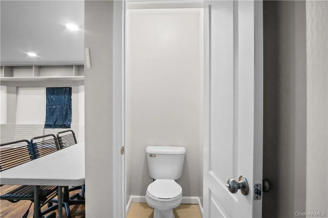 Bathroom featuring tile patterned flooring and toilet Bathroom featuring tile patterned flooring and toilet