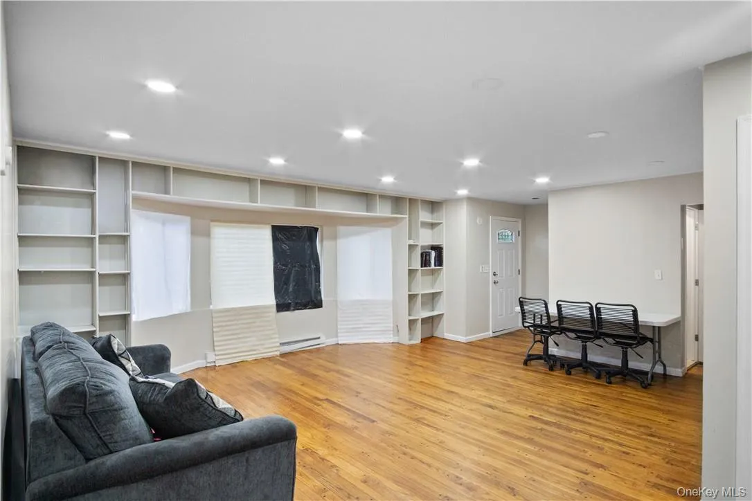 Living room with a baseboard heating unit and light hardwood / wood-style floors Living room with a baseboard heating unit and light hardwood / wood-style floors